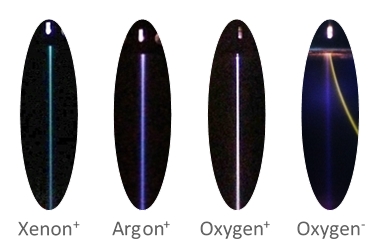 Photos of four different parallel beams: positive beams of xenon, argon, and oxygen, and a negative oxygen beam (including deflected electron beam)